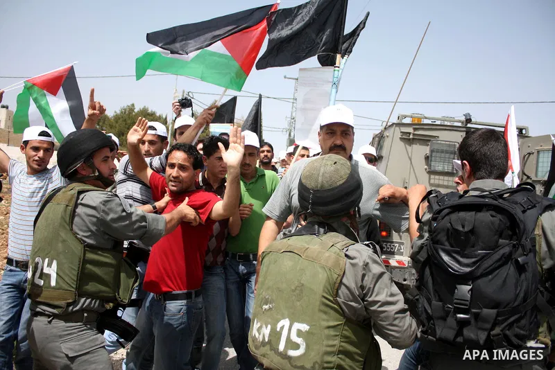 Israeli soldiers scuffle with demonstrators during a protest against Israel's controversial separation barrier and to mark "Land Day" in the West Bank village of Maasarah, near the biblical town of Bethlehem, on April 01...