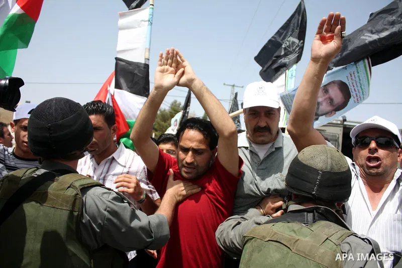 Israeli soldiers scuffle with demonstrators during a protest against Israel's controversial separation barrier and to mark "Land Day" in the West Bank village of Maasarah, near the biblical town of Bethlehem, on April 01...