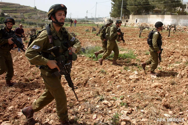 Israeli soldiers scuffle with demonstrators during a protest against Israel's controversial separation barrier and to mark "Land Day" in the West Bank village of Maasarah, near the biblical town of Bethlehem, on April 01...
