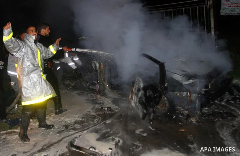Members of civil defence try to stop fire in a car after an Israeli air strike in Deir Al-Balah in the central Gaza Strip early April 2, 2011. Israeli aircraft killed three Palestinian gunmen in the southern Gaza Strip e...