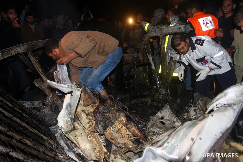Members of Hamas' security forces inspect a car after an Israeli air strike in Deir Al-Balah in the central Gaza Strip early April 2, 2011. Israeli aircraft killed three Palestinian gunmen in the southern Gaza Strip earl...