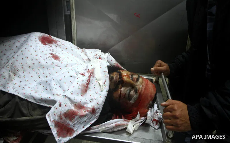 Members of Hamas' security forces stand next to the body of a militant after an Israeli air strike in Deir Al-Balah in the central Gaza Strip April 2, 2011. Israeli aircraft killed three Palestinian gunmen in the souther...