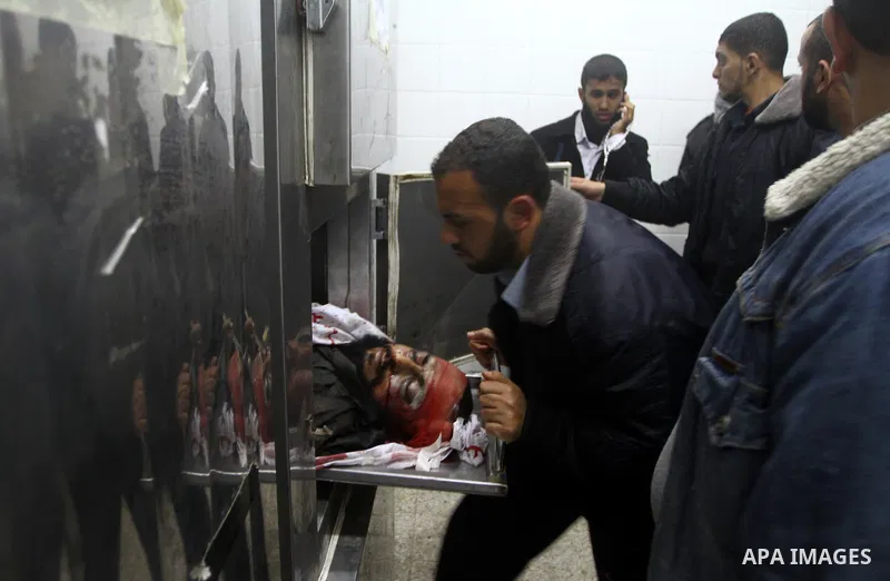 Members of Hamas' security forces stand next to the body of a militant after an Israeli air strike in Deir Al-Balah in the central Gaza Strip April 2, 2011. Israeli aircraft killed three Palestinian gunmen in the souther...