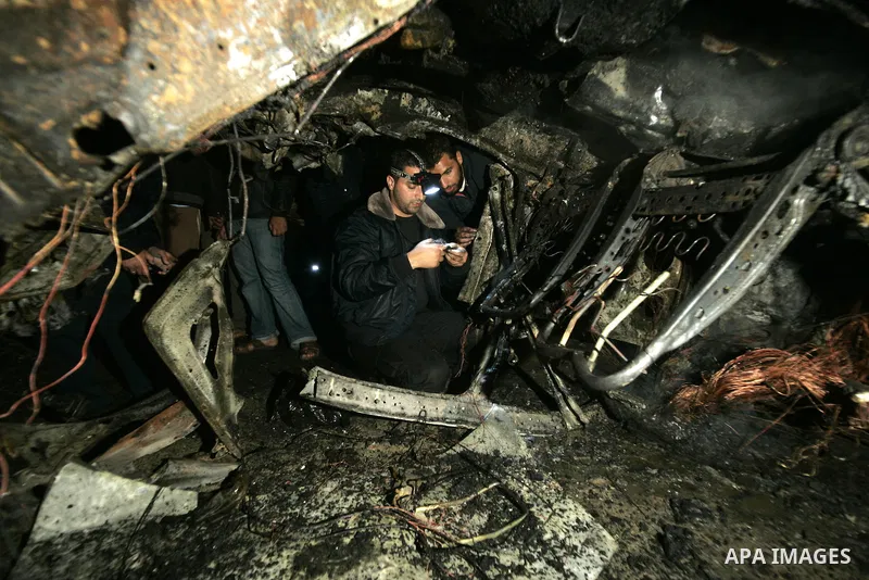 Palestinian Hamas officers inspect a vehicle following an Israeli airstrike that killed three of Hamas militants near Deir Al Balah, central Gaza Strip, early Saturday, April 2, 2011. Israeli aircraft killed the militant...