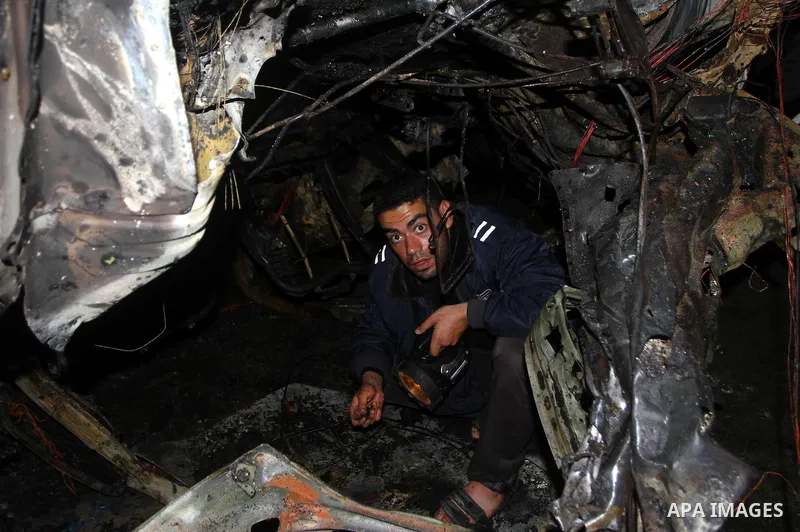Palestinian Hamas officer inspects a vehicle following an Israeli airstrike that killed three of Hamas militants near Deir Al Balah, central Gaza Strip, early Saturday, April 2, 2011. Israeli aircraft killed the militant...