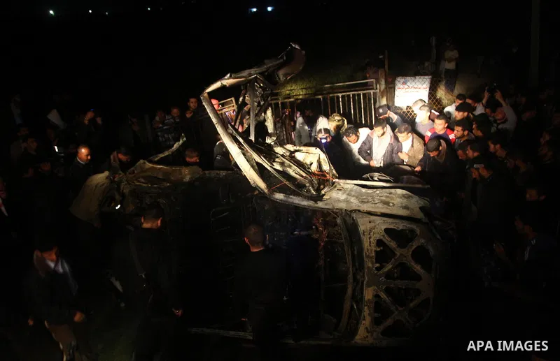 Palestinians surround the wreckage of a vehicle following an Israeli airstrike that killed three of Hamas militants near Deir Al Balah, central Gaza Strip. April 2, 2011. Israeli aircraft killed the militants early Satur...