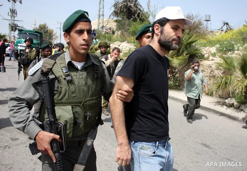 Israeli soldiers detain a demonstrator during a protest by foreign, Israeli and Palestinian demonstrators against the controversial Israeli separation barrier, in the Palestinian village of Beit Omar, near the West Bank...