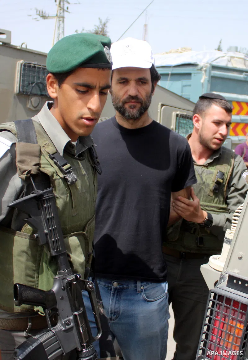 Israeli soldiers detain a demonstrator during a protest by foreign, Israeli and Palestinian demonstrators against the controversial Israeli separation barrier, in the Palestinian village of Beit Omar, near the West Bank...