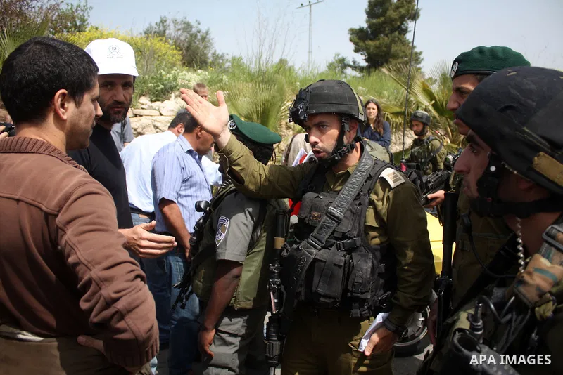 A Palestinian boy argues with Israeli soldiers during a protest by foreign, Israeli and Palestinian demonstrators against the controversial Israeli separation barrier, in the Palestinian village of Beit Omar, near the We...