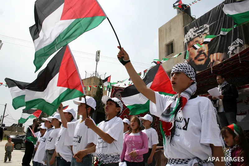 Palestinian children hold up national flags during a rally against the settlements and Israel's separation barrier in the West Bank village of Nabi Salah, near Ramallah on April 2,2011. Photo by Issam Rimawi