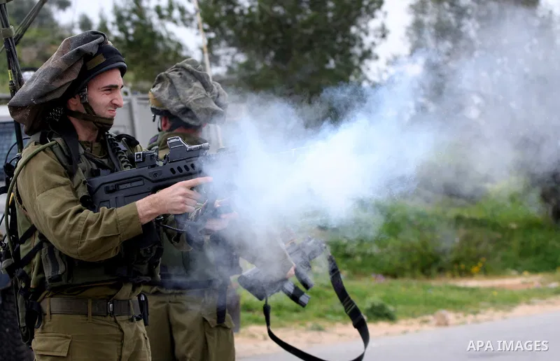 Israeli soldiers fire tear gas canisters towards Palestinian youths during a demonstration against the expansion of the nearby Jewish settlement of Halamish in the West Bank village of Nabi Saleh near Ramallah, Saturday,...