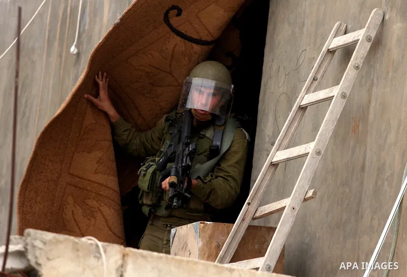An Israeli soldier takes position during a demonstration against the expansion of the nearby Jewish settlement of Halamish in the West Bank village of Nabi Saleh near Ramallah, Saturday, April 2, 2011. Photo by Issam Rim...