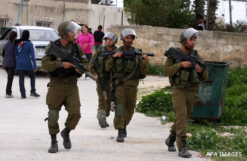 Israeli border police officers walk out of Palestinian houses during clashes at a protest against the expansion of the nearby Jewish settlement of Halamish in the West Bank village of Nabi Saleh near Ramallah, Saturday,...
