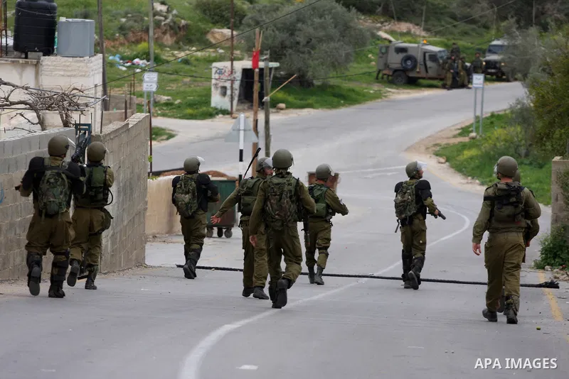 Israeli border police officers walk out of Palestinian houses during clashes at a protest against the expansion of the nearby Jewish settlement of Halamish in the West Bank village of Nabi Saleh near Ramallah, Saturday,...