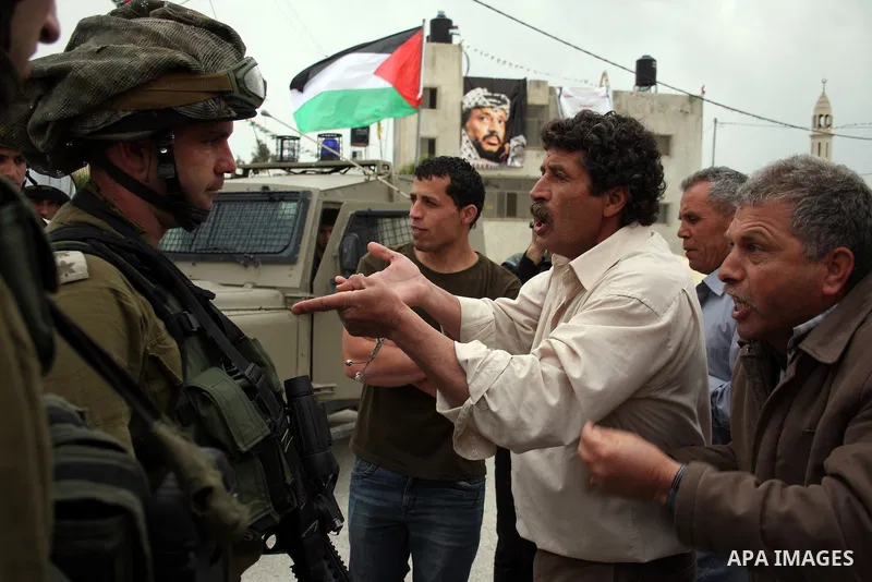 Israeli soldiers argue with a Palestinian man during a demonstration against the expansion of the nearby Jewish settlement of Halamish in the West Bank village of Nabi Saleh near Ramallah, Saturday, April 2, 2011. Photo...