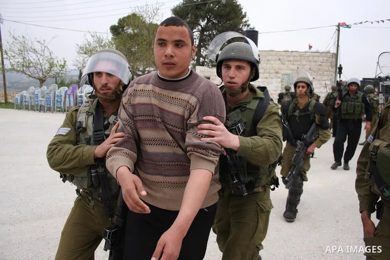 Israeli soldiers detain a Palestinian youth who they said was throwing stones during a demonstration against the expansion of the nearby Jewish settlement of Halamish in the West Bank village of Nabi Saleh near Ramallah,...