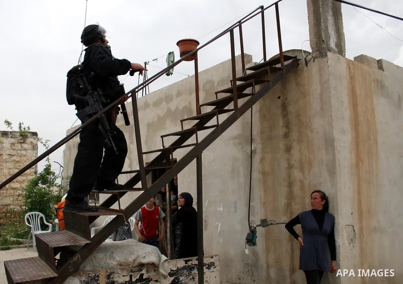 An Israeli border police officer walks out of a Palestinian house during clashes at a protest against the expansion of the nearby Jewish settlement of Halamish in the West Bank village of Nabi Saleh near Ramallah, Saturd...