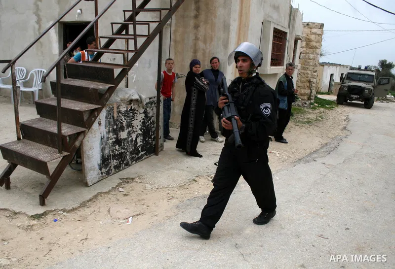 An Israeli border police officer walks out of a Palestinian house during clashes at a protest against the expansion of the nearby Jewish settlement of Halamish in the West Bank village of Nabi Saleh near Ramallah, Saturd...