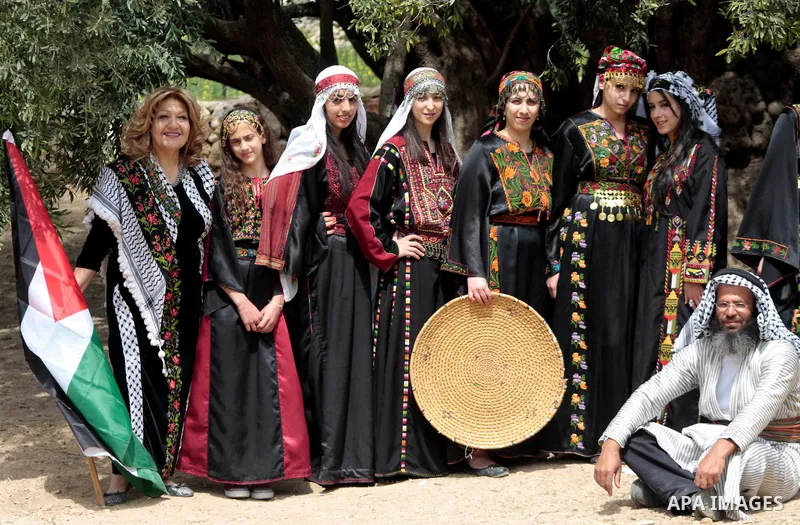Palestinians plant olive tree near a Walajah's giant ancient olive tree, which the residents of the West Bank village say is the oldest in the Palestinian territories on April 03,2011, while Israeli earthmovers tear up a...