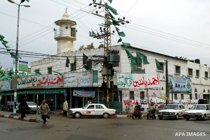 Palestinians walk past posters in Rafah in the southern Gaza Strip, on April 4, 2011, a day after Israel demanded that the United Nations bin a report critical of its deadly 2008-2009 offensive on Gaza after the author s...