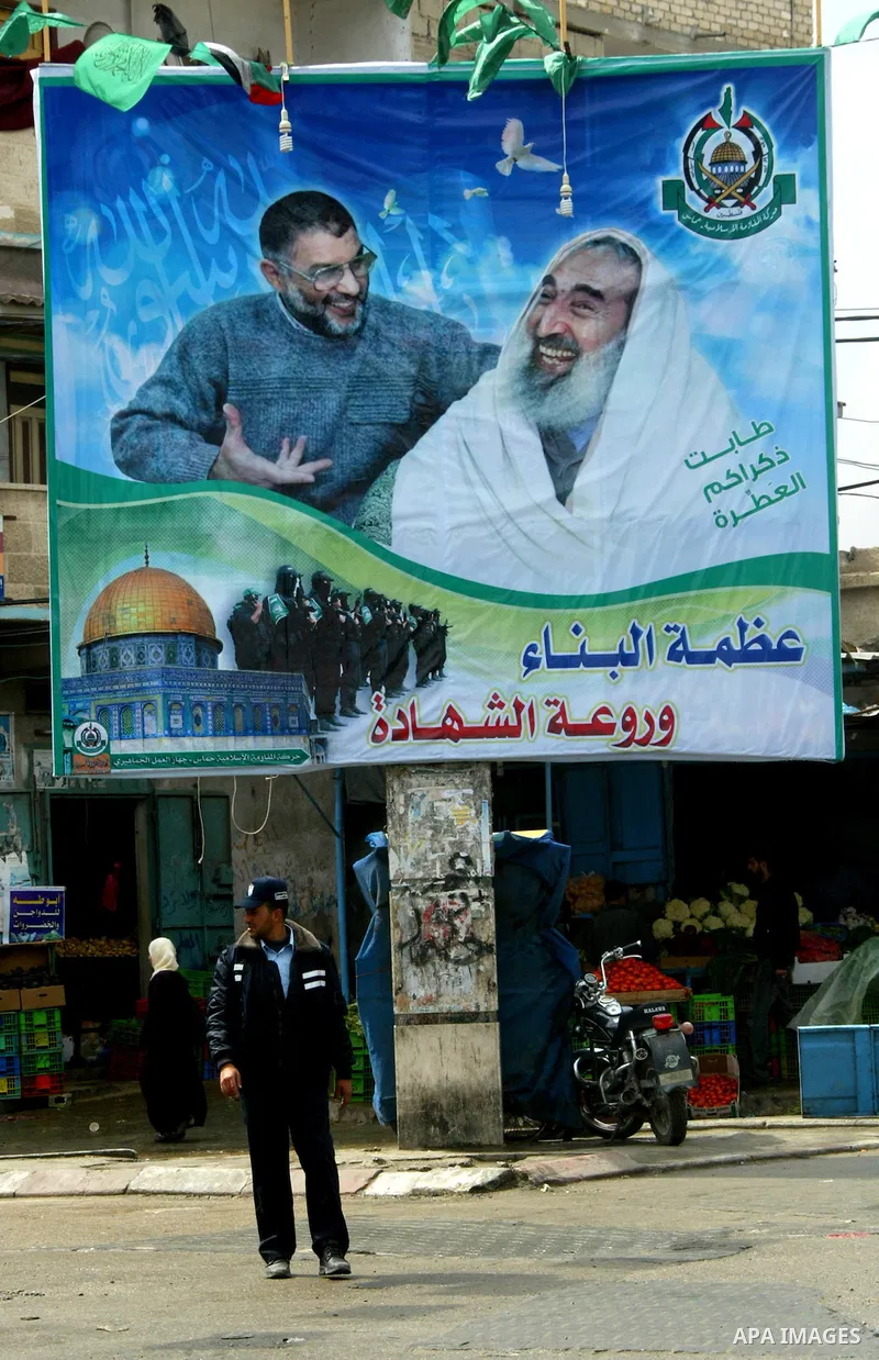 Palestinians walk past posters in Rafah in the southern Gaza Strip, on April 4, 2011, a day after Israel demanded that the United Nations bin a report critical of its deadly 2008-2009 offensive on Gaza after the author s...