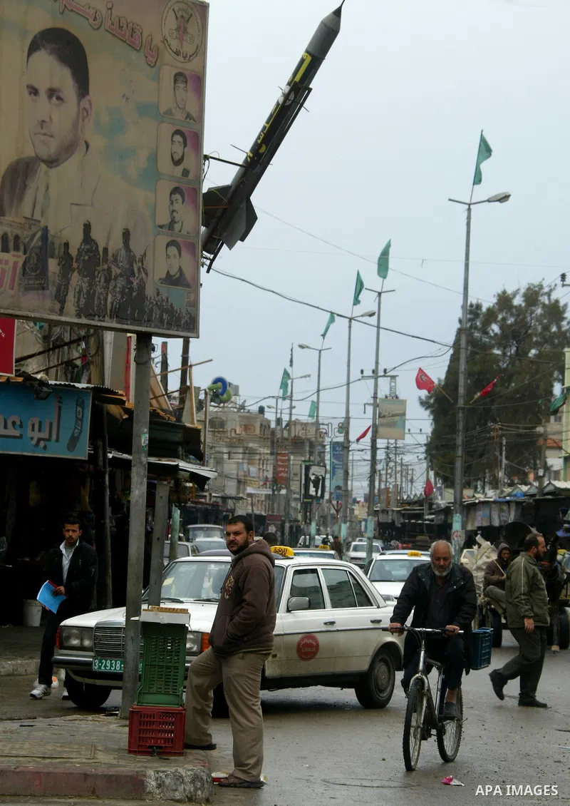 Palestinians walk past posters in Rafah in the southern Gaza Strip, on April 4, 2011, a day after Israel demanded that the United Nations bin a report critical of its deadly 2008-2009 offensive on Gaza after the author s...