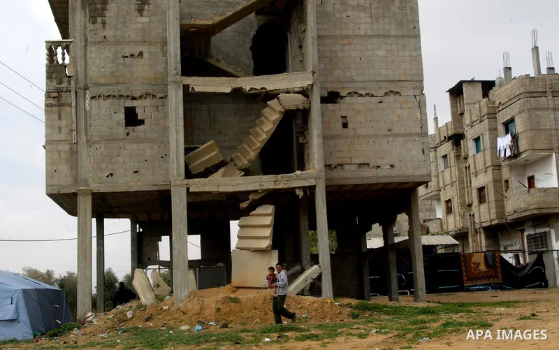 A Palestinian man walks past a destroyed building in Rafah, damaged during the 22-day Israeli offensive on the Gaza Strip, on April 4, 2011, a day after Israel demanded that the United Nations bin a report critical of it...