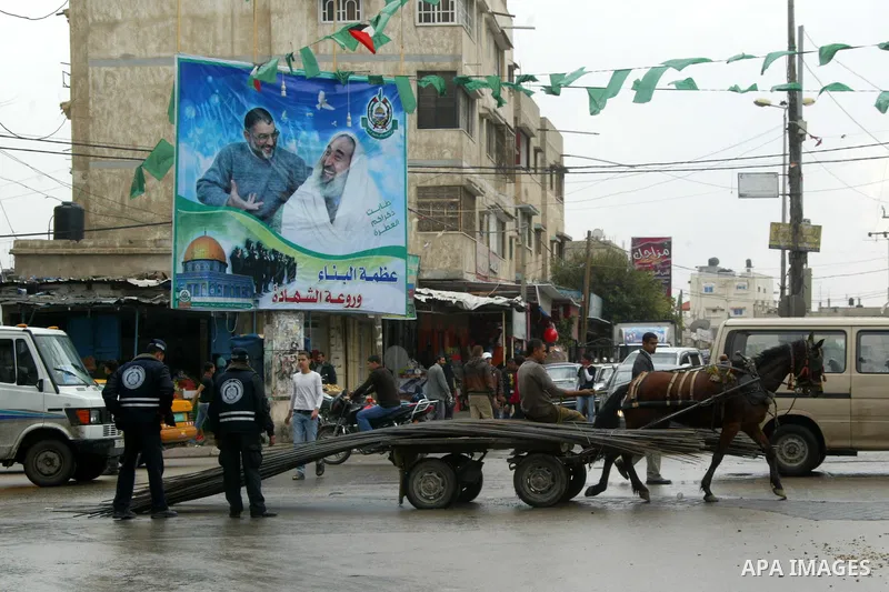 Palestinians walk past posters in Rafah in the southern Gaza Strip, on April 4, 2011, a day after Israel demanded that the United Nations bin a report critical of its deadly 2008-2009 offensive on Gaza after the author s...