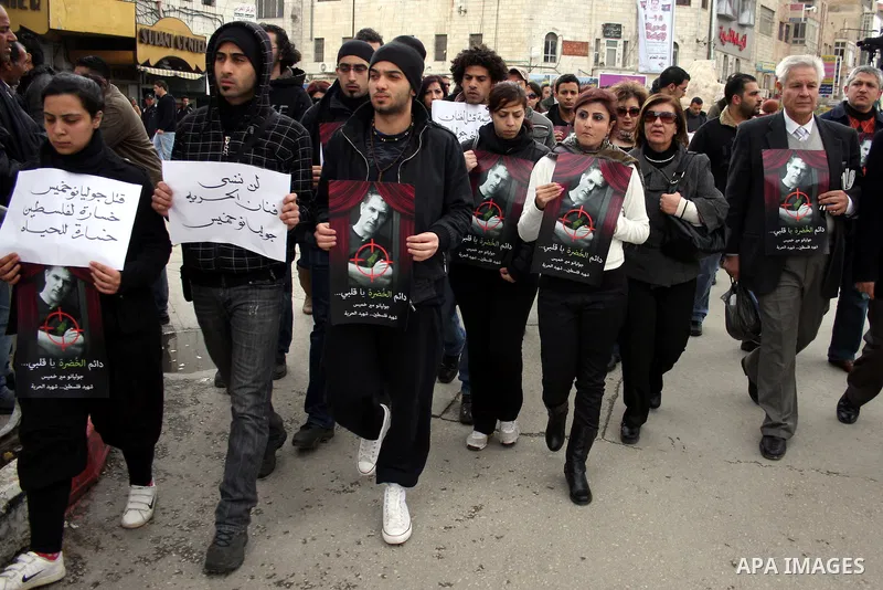 Palestinians hold signs and posters depicting Arab-Israeli actor and director Juliano Mer Khamis during a rally in the West Bank city of Ramallah on April 5, 2011. A senior Palestinian security official said on Tuesday p...
