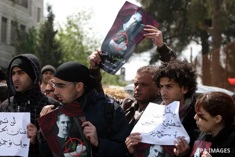 Palestinians hold signs and posters depicting Arab-Israeli actor and director Juliano Mer Khamis during a rally in the West Bank city of Ramallah on April 5, 2011. A senior Palestinian security official said on Tuesday p...