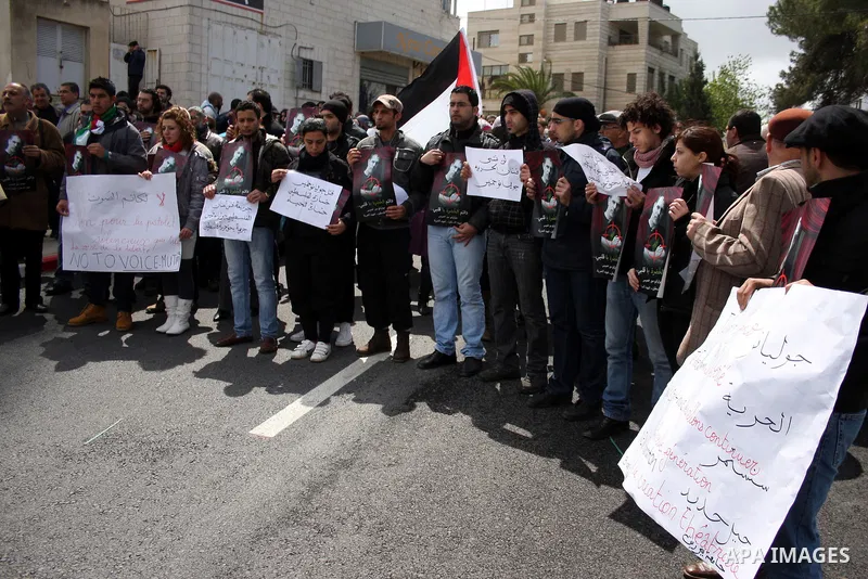 Palestinians hold signs and posters depicting Arab-Israeli actor and director Juliano Mer Khamis during a rally in the West Bank city of Ramallah on April 5, 2011. A senior Palestinian security official said on Tuesday p...