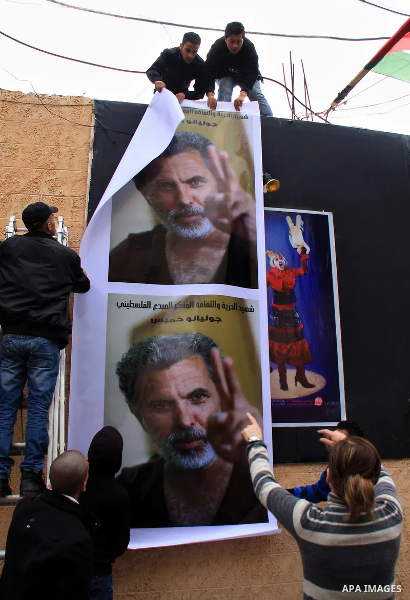 Palestinians hang a banner depicting Arab-Israeli actor and director Juliano Mer Khamis during a rally outside the Freedom Theatre, owned by Mer Khamis, in Jenin refugee camp, near the West Bank city of Jenin April 5, 20...