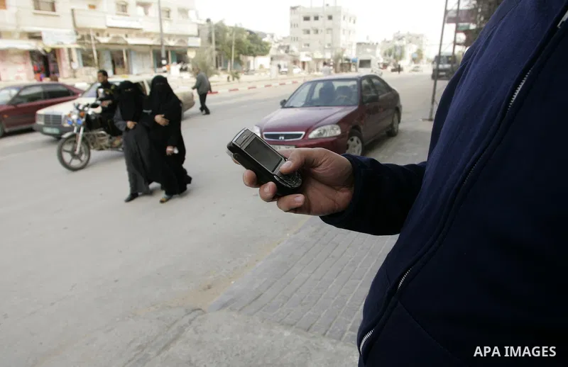 Palestinian man looks at his mobile phone after he received SMS message from the Israeli intelligence in Rafah, southern Gaza Strip on April 05,2011. Israeli intelligence services use SMS messages to search for the soldi...