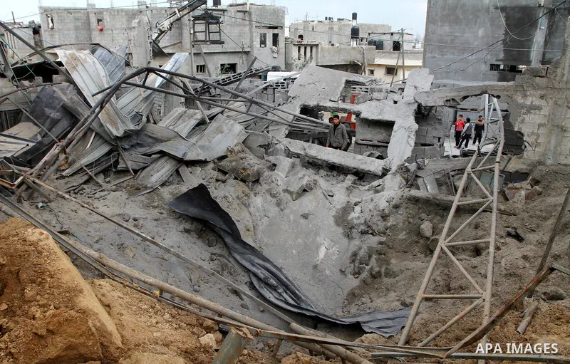 Palestinians inspect a destroyed plastics factory in Gaza City on April 6, 2011, after Israeli aircraft attacked two targets in the Gaza Strip wounding four people, among them a pregnant woman, Palestinian medics and wit...