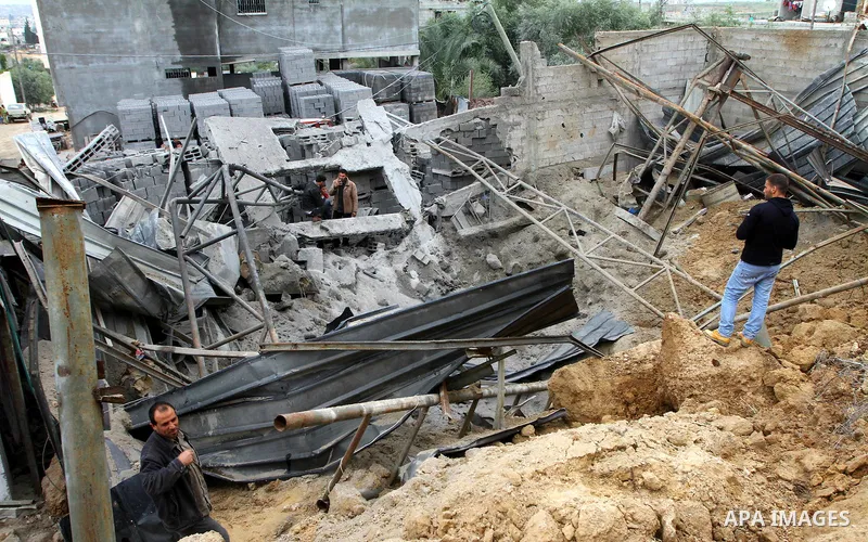 Palestinians inspect a destroyed plastics factory in Gaza City on April 6, 2011, after Israeli aircraft attacked two targets in the Gaza Strip wounding four people, among them a pregnant woman, Palestinian medics and wit...