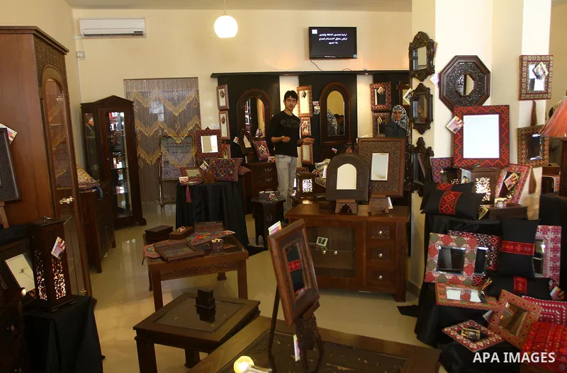 Palestinians walk through furniture were done by Palestinian deaf craft youths during an exhibition " future exhibition for the hand industries" in Gaza city on April 6,2011. Photo by Ashraf Amra