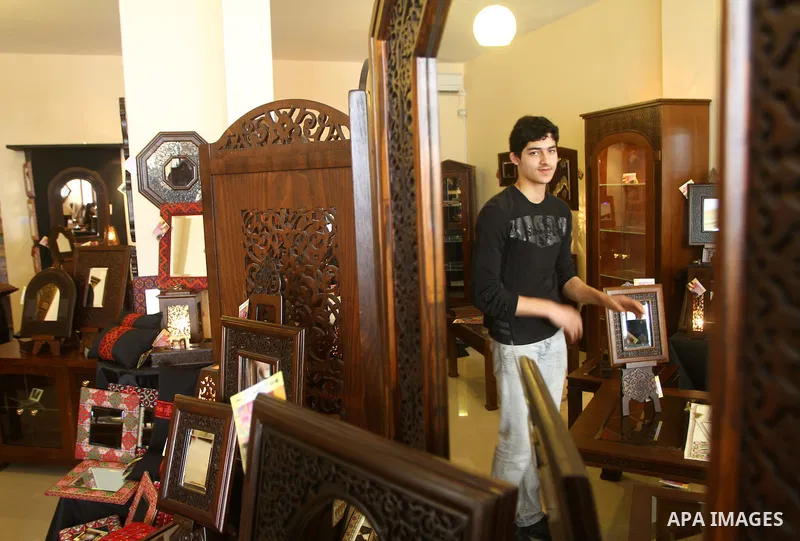 Palestinians walk through furniture were done by Palestinian deaf craft youths during an exhibition " future exhibition for the hand industries" in Gaza city on April 6,2011. Photo by Ashraf Amra