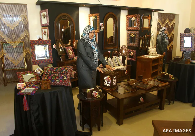 Palestinians walk through furniture were done by Palestinian deaf craft youths during an exhibition " future exhibition for the hand industries" in Gaza city on April 6,2011. Photo by Ashraf Amra