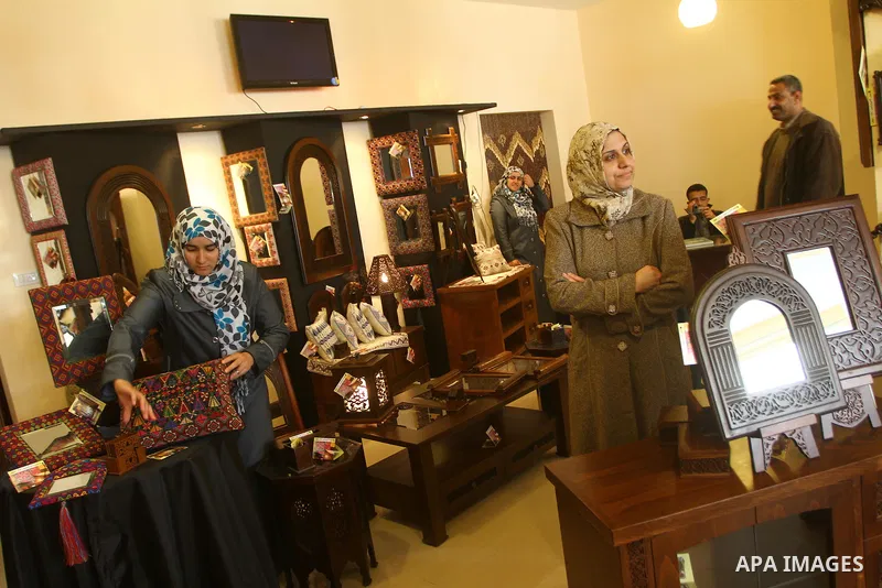 Palestinians walk through furniture were done by Palestinian deaf craft youths during an exhibition " future exhibition for the hand industries" in Gaza city on April 6,2011. Photo by Ashraf Amra