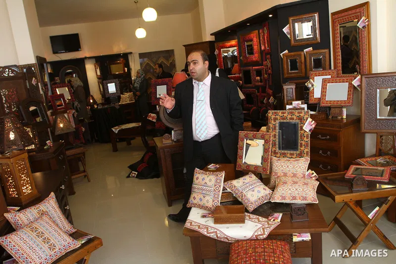 Palestinians walk through furniture were done by Palestinian deaf craft youths during an exhibition " future exhibition for the hand industries" in Gaza city on April 6,2011. Photo by Ashraf Amra