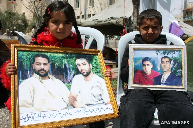 Palestinian women hold pictures of jailed relatives during a protest in the West Bank city of Bethlehem calling for their release from Israeli prisons on April 06, 2011. Photo by Najeh Hashlamoun