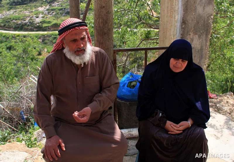 Palestinian Asad Lolah and his wife Rehab Lolah sit at the family house's yard after their release from an Israeli army overnight detention, in the West Bank village of Awarta near Nablus, Thursday, April 7, 2011. Palest...
