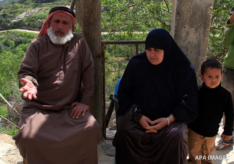 Palestinian Asad Lolah and his wife Rehab Lolah sit at the family house's yard after their release from an Israeli army overnight detention, in the West Bank village of Awarta near Nablus, Thursday, April 7, 2011. Palest...