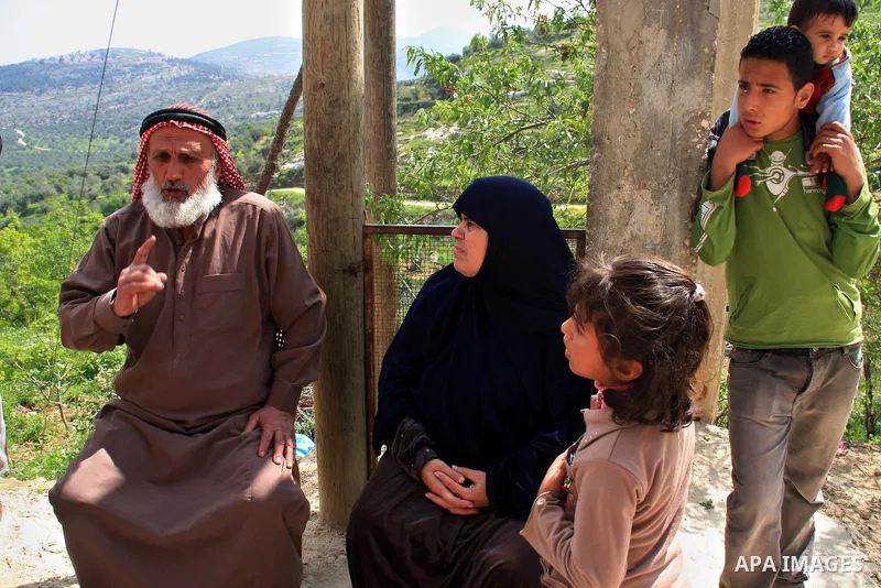 Palestinian Asad Lolah and his wife Rehab Lolah sit at the family house's yard after their release from an Israeli army overnight detention, in the West Bank village of Awarta near Nablus, Thursday, April 7, 2011. Palest...
