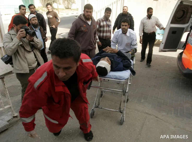 A wounded Palestinian man is wheeled by medics at the al_Najar hospital in the southern Gaza Strip, Wednesday, April 7, 2011, after his house was hit by Israeli shell fired towards Gaza Strip near the border between sout...