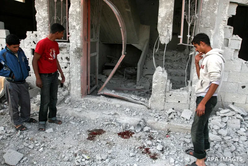 Palestinian children stand next the damaged house after an Israeli airstrike east of Gaza City, Thursday, April 7, 2011. An anti-tank missile fired from the Gaza Strip struck a school bus in southern Israel Thursday, wou...
