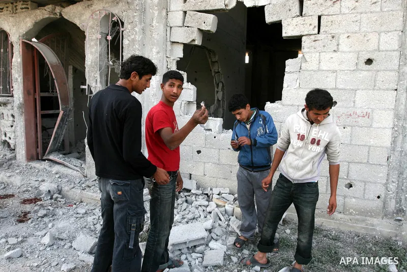 Palestinian children stand next the damaged house after an Israeli airstrike east of Gaza City, Thursday, April 7, 2011. An anti-tank missile fired from the Gaza Strip struck a school bus in southern Israel Thursday, wou...