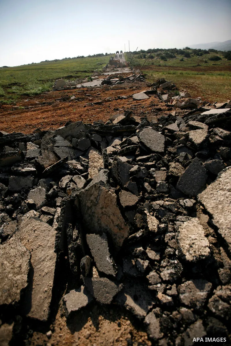 An Israeli earth-mover destroys a main road in Aqaba near the West Bank village of Tubas in the northern Jenin region on April 7, 2011 as the military used bulldozers to destroy Palestinian houses in another farming vill...