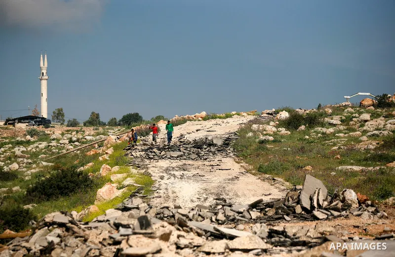 An Israeli earth-mover destroys a main road in Aqaba near the West Bank village of Tubas in the northern Jenin region on April 7, 2011 as the military used bulldozers to destroy Palestinian houses in another farming vill...