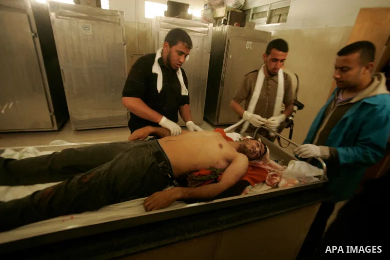 Palestinian youths check the body of a man killed by Israeli tank shell yesterday, at a morgue in al-Najar hospital in the southern Gaza Strip town of Rafah on April 8, 2011. Palestinian officials in Gaza reported that t...